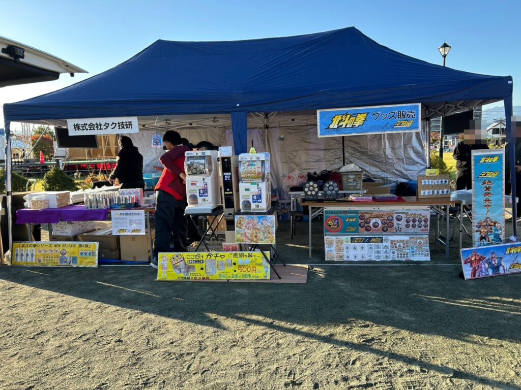 佐久平ハーフマラソン2026 「北斗の拳 グッズ販売」の幕を掲げたタク技研ブース